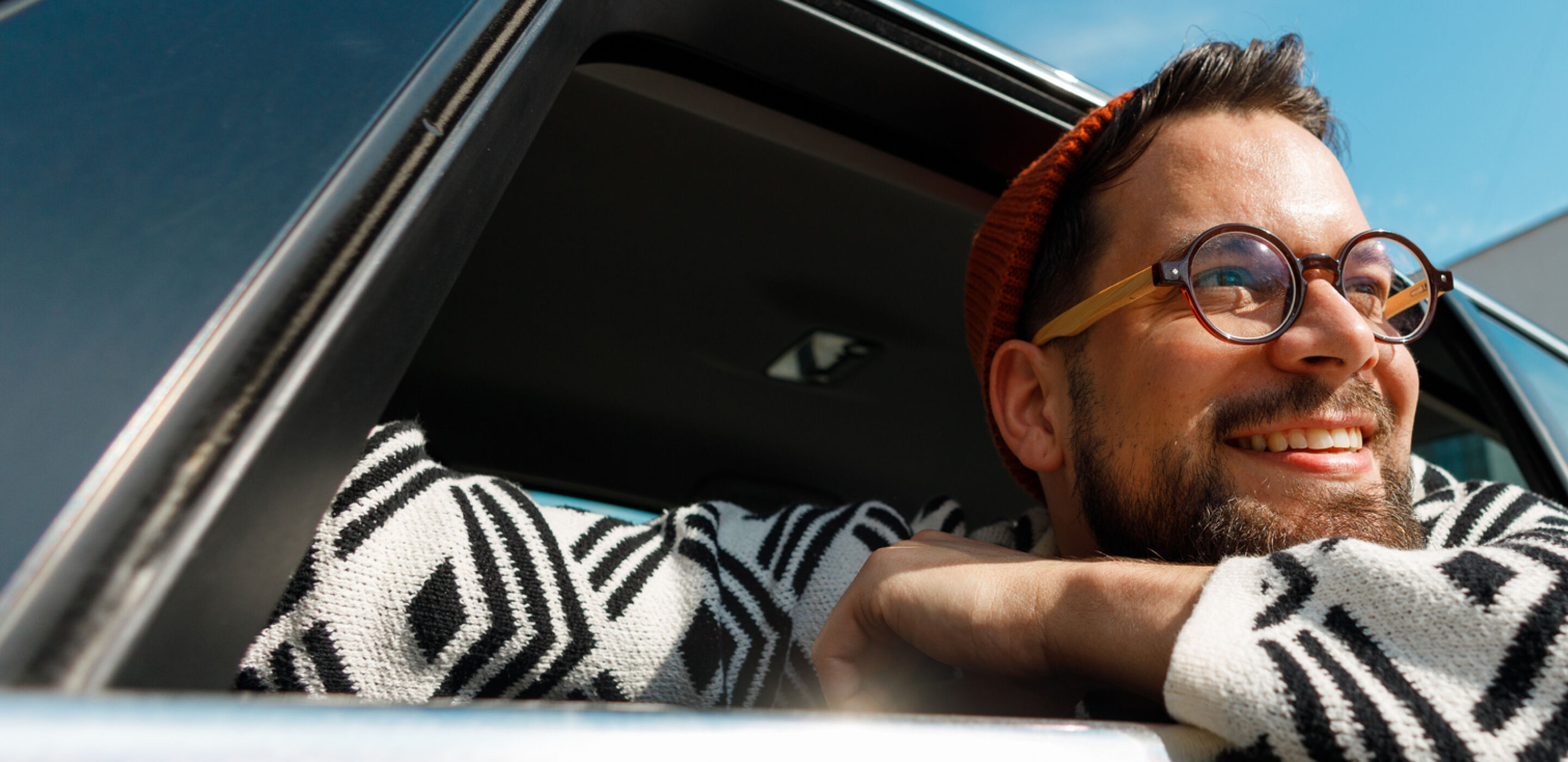 Man looking out of a car whilst wearing glasses