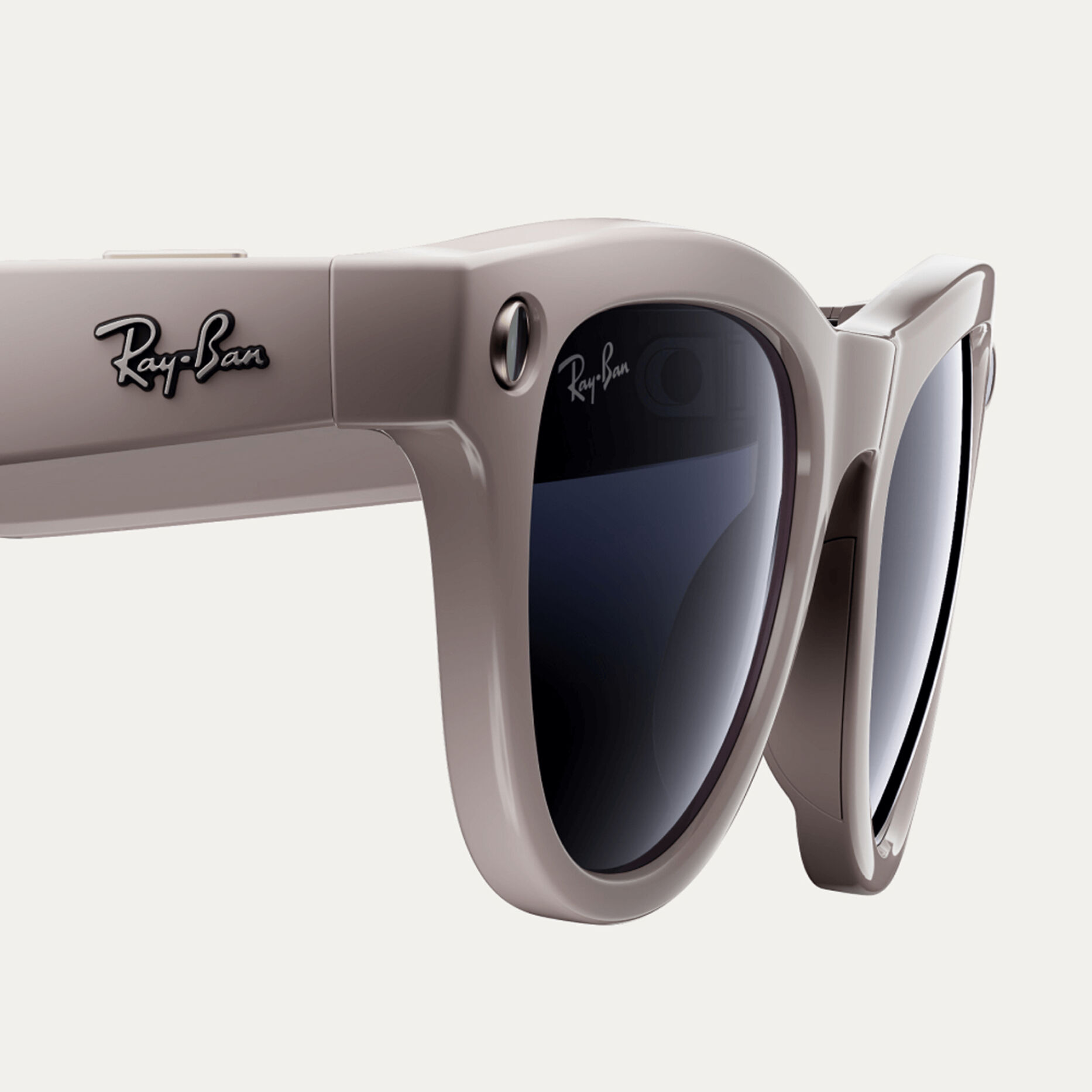 Beige-framed Ray-Ban sunglasses with dark lenses.