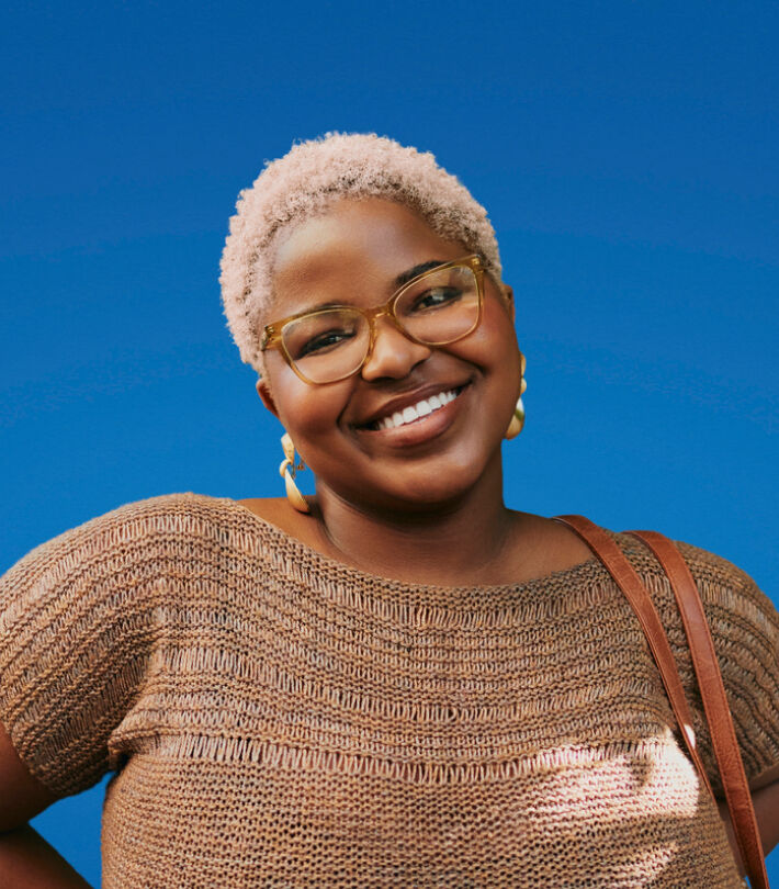 Smiling person wearing well-cared boots prescription glasses