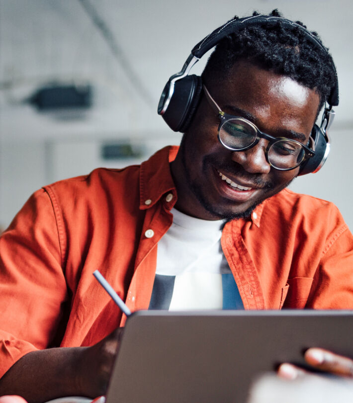 Person wearing boots opticians glasses drawing on a tablet, expressing creativity and focus