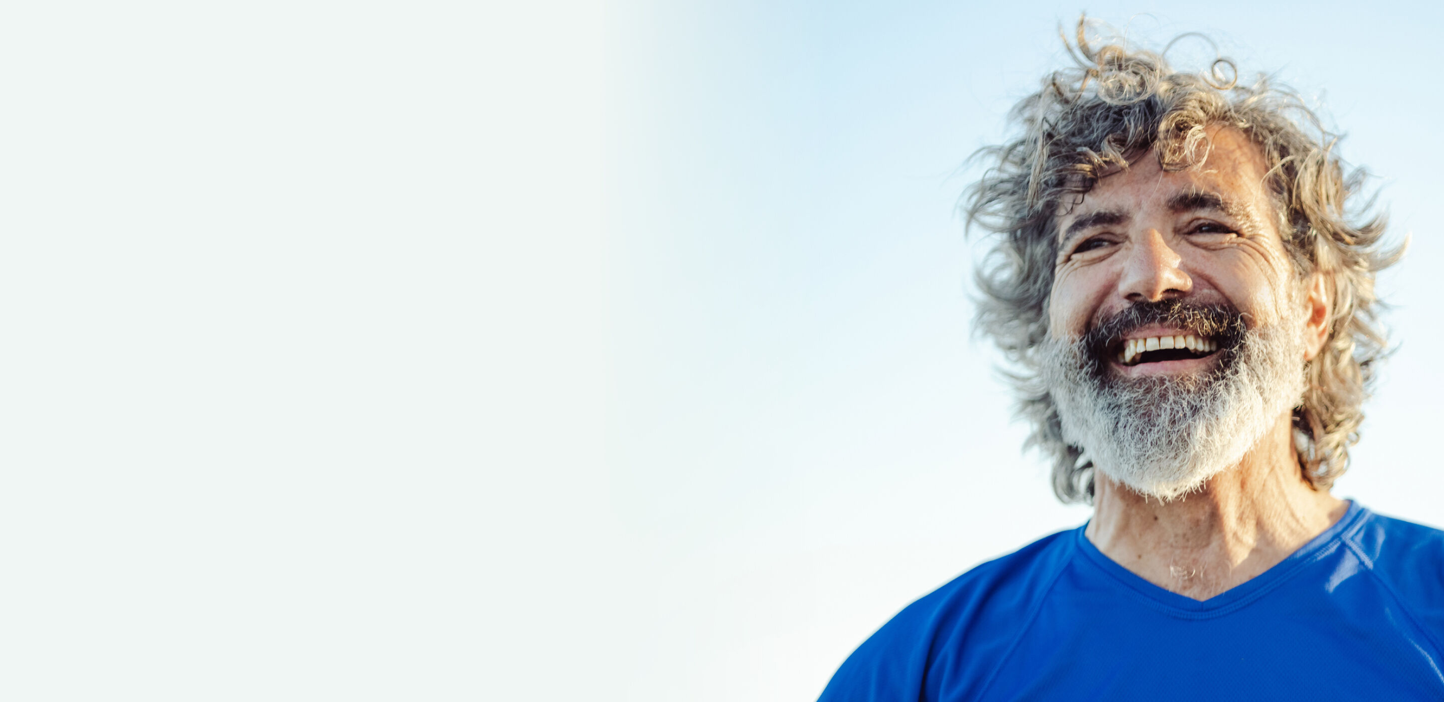 Smiling man outdoors representing confidence and wellbeing supported by NHS eye care services.