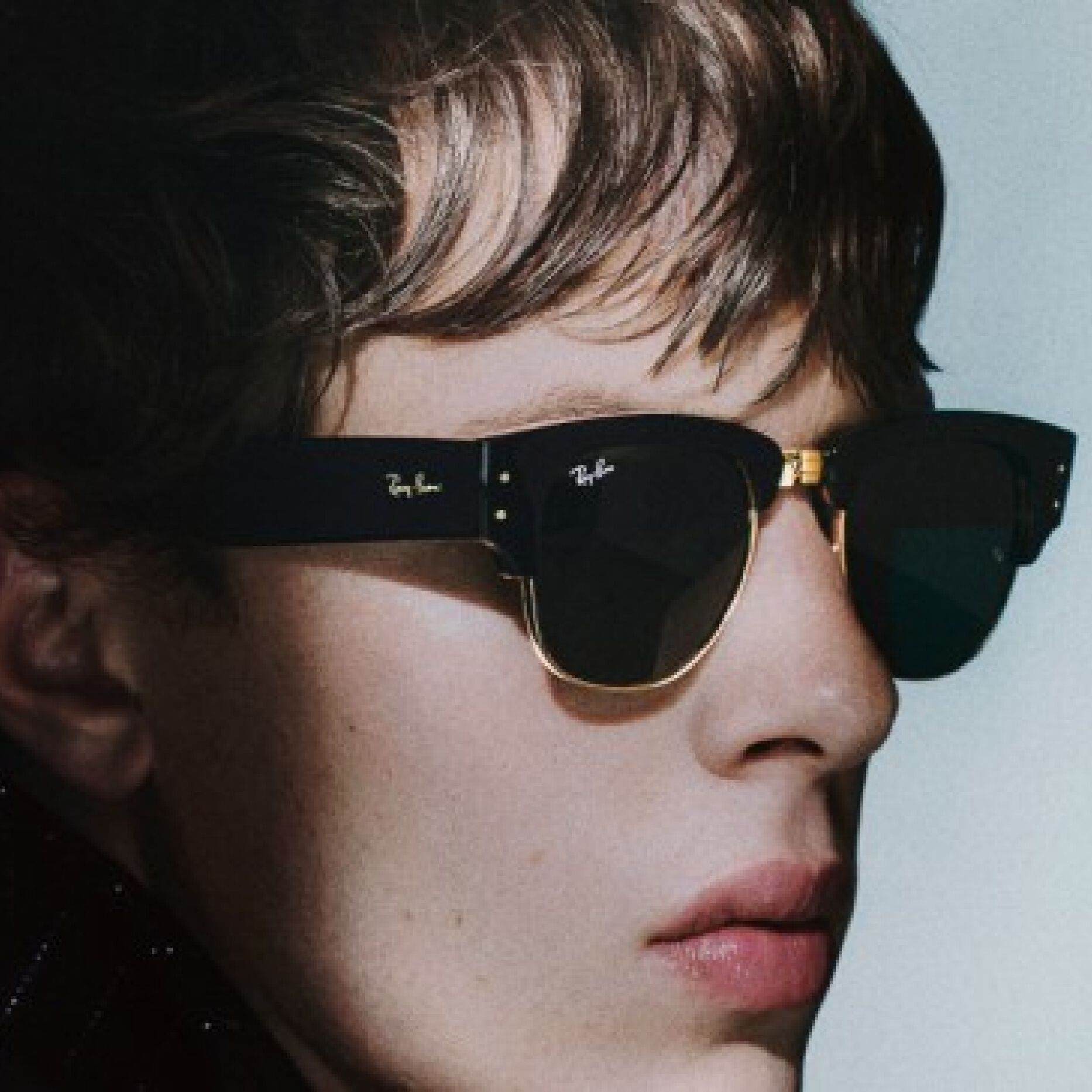 Close-up of stylish black Ray-Ban sunglasses with gold accents, sleek design